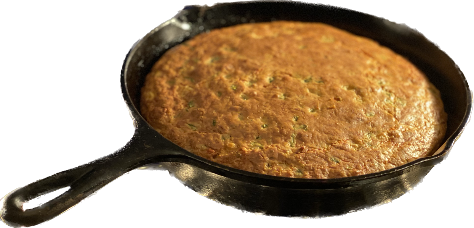 Golden poblano, bacon, and cheddar skillet cornbread cut into wedges in a cast-iron pan.